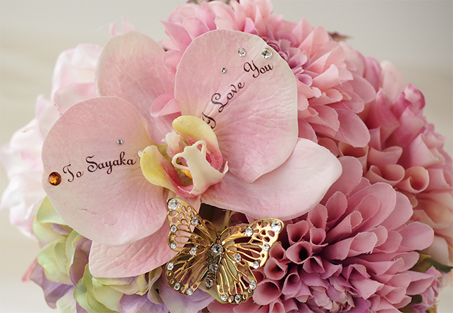 ピンク色の胡蝶蘭と花びらのメッセージ