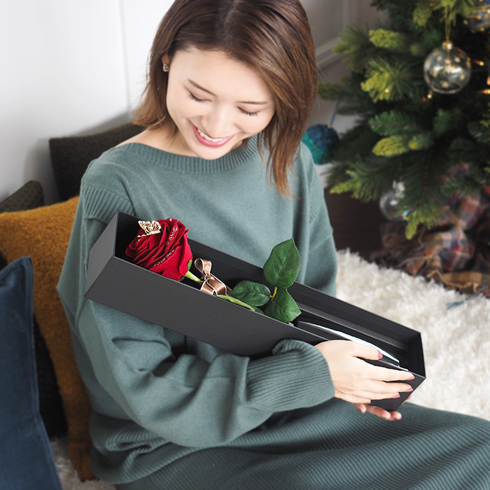 1本の赤バラをプレゼントされて喜ぶ女性